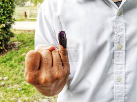 Foto de Tinta púrpura en el dedo después de las elecciones presidenciales en Indonesia en la página abierta en 2024 - Imagen libre de derechos