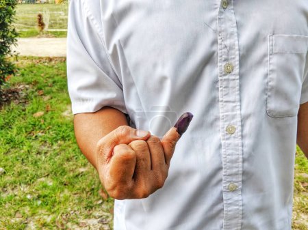 Foto de Tinta púrpura en el dedo después de las elecciones presidenciales en Indonesia en la página abierta en 2024 - Imagen libre de derechos
