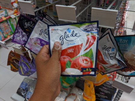 Sambas, Indonesia-February 18, 2023: hand holding the glade room freshener packaging sold at toko