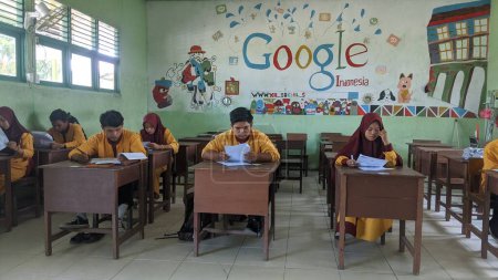 Téléchargez les photos : Sambas, Indonésie-Mars 22, 2024 : lycéens travaillant sur des questions d'évaluation à l'intérieur - en image libre de droit