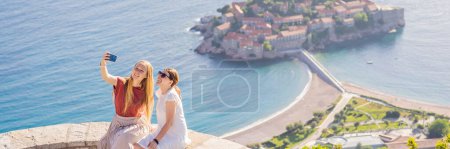 Photo for BANNER, LONG FORMAT Two Woman tourist on background of beautiful view of the island of St. Stephen, Sveti Stefan on the Budva Riviera, Budva, Montenegro. Travel to Montenegro concept. - Royalty Free Image