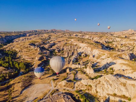 Foto de Coloridos globos de aire caliente volando en el valle de las chimeneas de hadas en Nevsehir, Goreme, Capadocia Turquía. Espectacular vista panorámica del dron de la ciudad subterránea y el turismo en globo. Alta calidad. - Imagen libre de derechos
