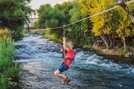 Téléchargez les photos : Une tyrolienne, une tyrolienne sur la rivière. Enfant aventure. - en image libre de droit