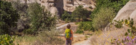 BANNER, LONG FORMAT Boy tourist on background of Unique geological formations in Love Valley in Cappadocia, popular travel destination in Turkey. Traveling with children in Turkey concept.