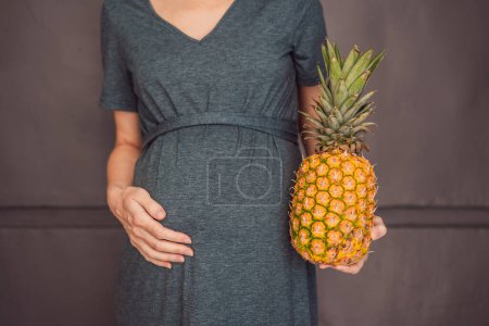 Téléchargez les photos : Un ventre de femme enceinte, montrant magnifiquement la taille de son bébé, assimilé à un ananas. Explorer les avantages et les inconvénients potentiels de l'ananas pendant la grossesse et l'accouchement. - en image libre de droit