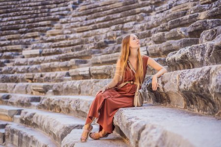 Photo for Woman tourist explores Aspendos Ancient City. Aspendos acropolis city ruins, cisterns, aqueducts and old temple. Aspendos Antalya Turkey. turkiye. - Royalty Free Image
