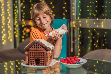 Immerse in festive delight as a boy crafts boy crafting an unconventional gingerbread house, infusing Christmas with unique creativity and festive cheer. A sweet scene of seasonal bonding and culinary