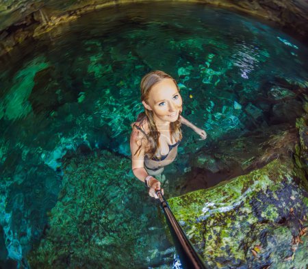 Woman immersed in the enchanting beauty of a Mexican cenote, surrounded by crystal-clear waters and captivating natural formations.