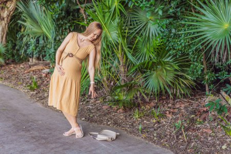 pregnant woman drops her keys and struggles to pick them up, highlighting the physical limitations that can arise during pregnancy. Patience and support become essential.