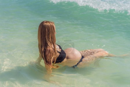 Téléchargez les photos : Dans l'étreinte idyllique de la mer des Caraïbes, une femme enceinte trouve le bonheur, savourant la chaleur et la sérénité des eaux tropicales pendant sa grossesse. - en image libre de droit