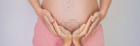 BANNER, LONG FORMAT Young beautiful pregnant woman and eldest son. The cute boy put his hands on his mothers belly. Expecting a baby in the family concept. Preparing an older child for a younger one.