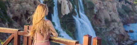 BANNER, LANG FORMAT Schöne Frau mit langen Haaren vor dem Hintergrund des Duden-Wasserfalls in Antalya. Berühmte Orte der Türkei. Unterer Dudenfall fällt von einer Felsklippe, die aus etwa 40 m Höhe in die Tiefe fällt