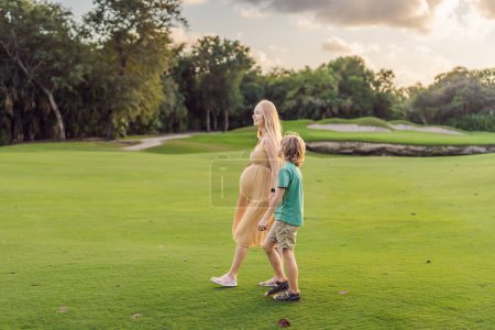 Herzerwärmendes Outdoor-Bonding, wenn eine schwangere Mutter und ihr Sohn die gemeinsame Zeit genießen, die Schönheit der Natur genießen und schöne Momente schaffen.
