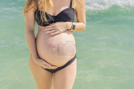 In the idyllic embrace of the Caribbean Sea, a pregnant woman finds bliss, savoring the warmth and serenity of the tropical waters during her pregnancy.