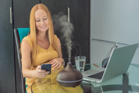 Expectant woman enhances work environment, using an aroma diffuser for a soothing atmosphere during pregnancy.