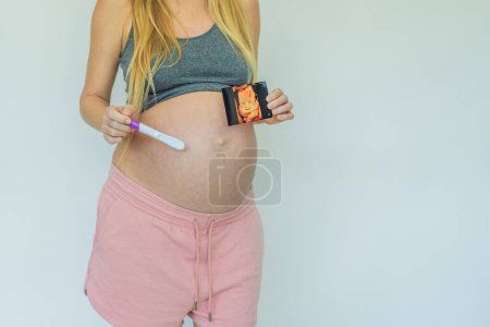 Mujer embarazada alegre comparte la emocionante noticia, orgullosamente mostrando su prueba de embarazo positiva y una foto de ultrasonido conmovedora.