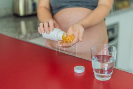 pregnant woman conscientiously takes fish oil capsules, rich in omega-3, prioritizing essential nutrients for a healthy pregnancy journey.