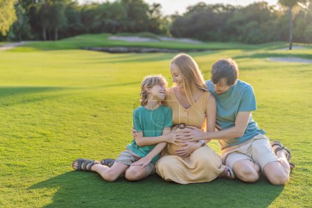 Freudige Familienzeit als schwangere Frau, ihr Mann und ihr Sohn teilen schöne Momente im Freien, umarmen die Schönheit der Natur und schaffen gemeinsam gehegte Erinnerungen.