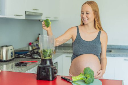 Eine schwangere Frau, die eine nahrhafte Wahl trifft, bereitet freudig einen lebhaften Gemüse-Smoothie zu, wobei sie gesunde Zutaten für ein optimales Wohlbefinden während ihrer Mutterschaftsreise in den Vordergrund stellt..