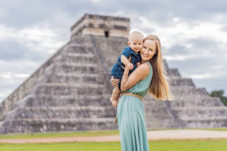 Schöne Touristin und ihr Baby beobachten die alte Pyramide und den Tempel des Schlosses der Maya-Architektur, bekannt als Chichen Itza. Dies sind die Ruinen dieses alten präkolumbianischen