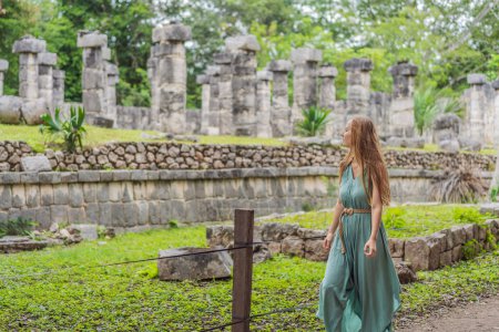 Belle femme touristique observant la vieille pyramide et le temple du château de l'architecture maya connu sous le nom de Chichen Itza. Ce sont les ruines de cette ancienne civilisation précolombienne et une partie de