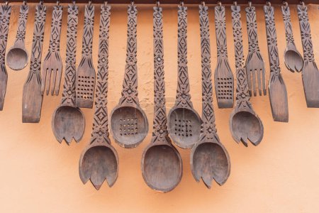 Una colección de grandes cucharas decorativas de madera añade un toque de encanto mexicano a un espacio al aire libre, mostrando artesanía tradicional y motivos culturales.