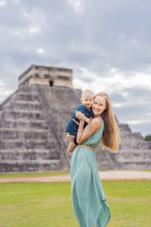 Photo for Beautiful tourist woman and her son baby observing the old pyramid and temple of the castle of the Mayan architecture known as Chichen Itza. These are the ruins of this ancient pre-columbian - Royalty Free Image