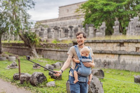 Touristes père et fils observant la vieille pyramide et le temple du château de l'architecture maya connu sous le nom de Chichen Itza. Ce sont les ruines de cette ancienne civilisation précolombienne et une partie de