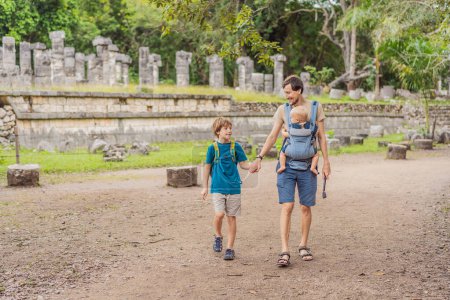 Photo for Father and two sons tourists observing the old pyramid and temple of the castle of the Mayan architecture known as Chichen Itza. These are the ruins of this ancient pre-columbian civilization and part - Royalty Free Image