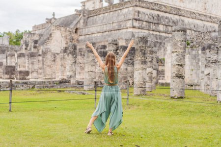 Photo for Beautiful tourist woman observing the old pyramid and temple of the castle of the Mayan architecture known as Chichen Itza. These are the ruins of this ancient pre-columbian civilization and part of - Royalty Free Image