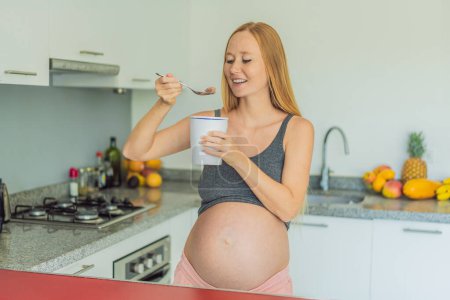 Glückliche schwangere junge Frau isst Eis.