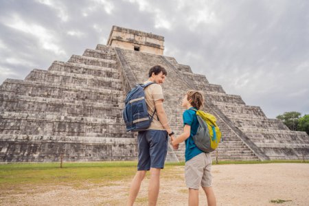 Vater und Sohn Touristen beobachten die alte Pyramide und den Tempel der Burg der Maya-Architektur, die als Chichen Itza bekannt ist. Dies sind die Ruinen dieser uralten präkolumbianischen Zivilisation und ein Teil von