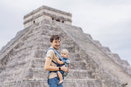 Foto de Padre e hijo turistas observando la antigua pirámide y templo del castillo de la arquitectura maya conocido como Chichén Itzá. Estas son las ruinas de esta antigua civilización precolombina y parte de - Imagen libre de derechos