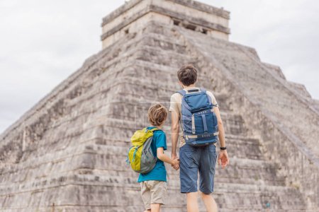 Vater und Sohn Touristen beobachten die alte Pyramide und den Tempel der Burg der Maya-Architektur, die als Chichen Itza bekannt ist. Dies sind die Ruinen dieser uralten präkolumbianischen Zivilisation und ein Teil von
