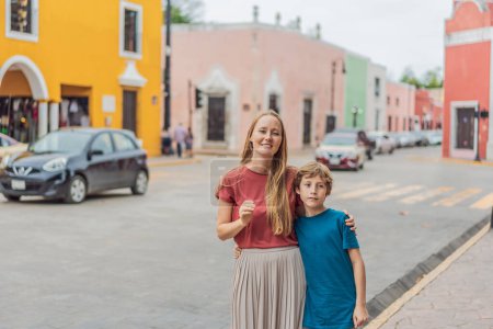 Mother and son tourists explore the vibrant streets of Valladolid, Mexico, immersing herself in the rich culture and colorful architecture of this charming colonial town.