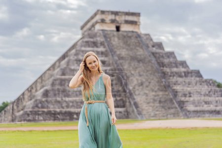 Hermosa turista observando la antigua pirámide y templo del castillo de la arquitectura maya conocido como Chichén Itzá. Estas son las ruinas de esta antigua civilización precolombina y parte de