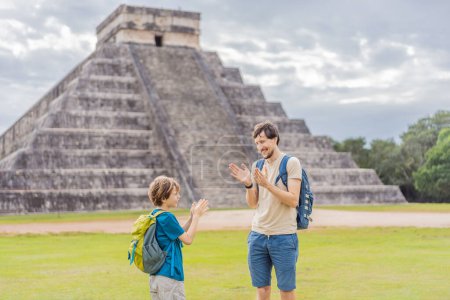 Padre e hijo turistas observando la antigua pirámide y templo del castillo de la arquitectura maya conocido como Chichén Itzá. Estas son las ruinas de esta antigua civilización precolombina y parte de