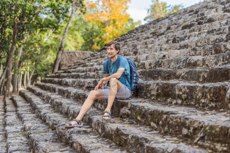 Mann Tourist in Coba, Mexiko. Antike Maya-Stadt in Mexiko. Coba ist ein archäologisches Gebiet und ein berühmtes Wahrzeichen der Halbinsel Yucatan. Bewölkter Himmel über einer Pyramide in Mexiko.