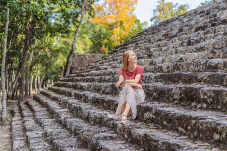 Turista mujer en Coba, México. Antigua ciudad maya en México. Coba es un área arqueológica y un famoso hito de la península de Yucatán. Cielo nublado sobre una pirámide en México.