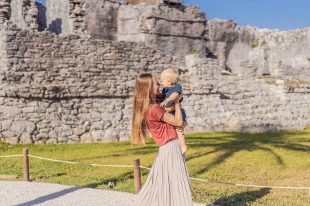 Mère et fils touristes profitant de la vue pré-colombienne ville fortifiée maya de Tulum, Quintana Roo, Mexique, Amérique du Nord, Tulum, Mexique. El Castillo - château la ville maya de Tulum temple principal.