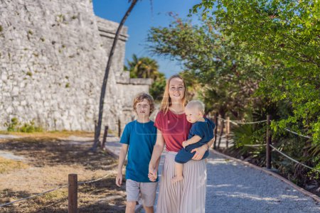 Mère et deux fils touristes profitant de la vue ville fortifiée maya précolombienne de Tulum, Quintana Roo, Mexique, Amérique du Nord, Tulum, Mexique. El Castillo - château la ville maya de Tulum temple principal.