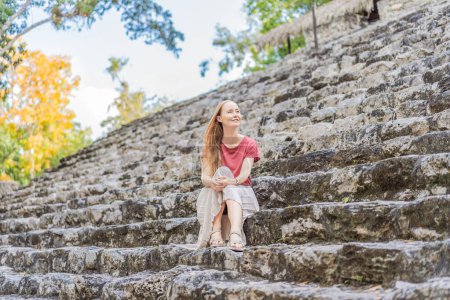 Touristin in Coba, Mexiko. Antike Maya-Stadt in Mexiko. Coba ist ein archäologisches Gebiet und ein berühmtes Wahrzeichen der Halbinsel Yucatan. Bewölkter Himmel über einer Pyramide in Mexiko.