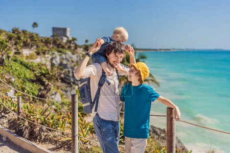 Vater und zwei Söhne Touristen genießen den Blick auf die präkolumbianische Maya-Stadt Tulum, Quintana Roo, Mexiko, Nordamerika, Tulum, Mexiko. El Castillo - Burg der Maya-Stadt Tulum Haupttempel.