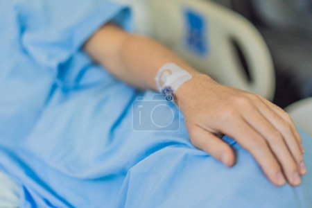 Una mujer en el hospital tiene un catéter insertado en su brazo para gotas intravenosas. El procedimiento médico se realiza para administrar líquidos, medicamentos o nutrientes directamente en su torrente sanguíneo, asegurando