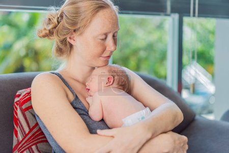 Maman avec bébé nouveau-né se détendre sur le canapé à la maison. Ce moment tendre souligne le lien entre la mère et l'enfant dans un environnement familial confortable et aimant.