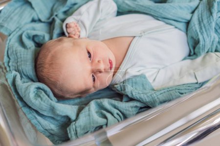 Ein Neugeborenes ruht friedlich in seinem durchsichtigen Bassinett im Krankenhaus. Die klare Bassinet bietet Sichtbarkeit für medizinisches Personal, um das Wohlbefinden der Babys zu überwachen und gleichzeitig eine sichere und komfortable