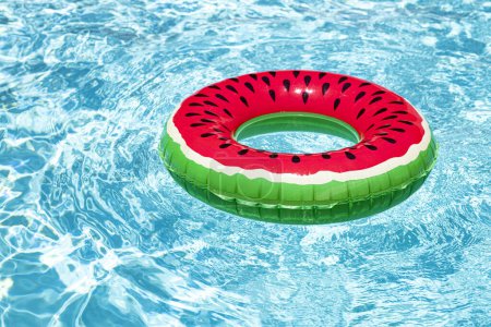 Téléchargez les photos : Concept vacances d'été. Anneau en caoutchouc dans la piscine. Anneau gonflable coloré flottant dans la piscine. Publicité estivale. Espace de copie - en image libre de droit