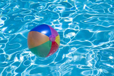 Téléchargez les photos : Flotteurs de piscine. Balle de plage dans la piscine. Fond estival. Balle de plage colorée flottant dans la piscine. Espace de copie pour la publicité - en image libre de droit