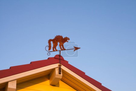 a cat weather vane on a roof
