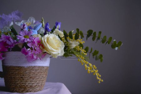     Easter floral arrangement with two blue Easter bunnies    in a wicker basket                    